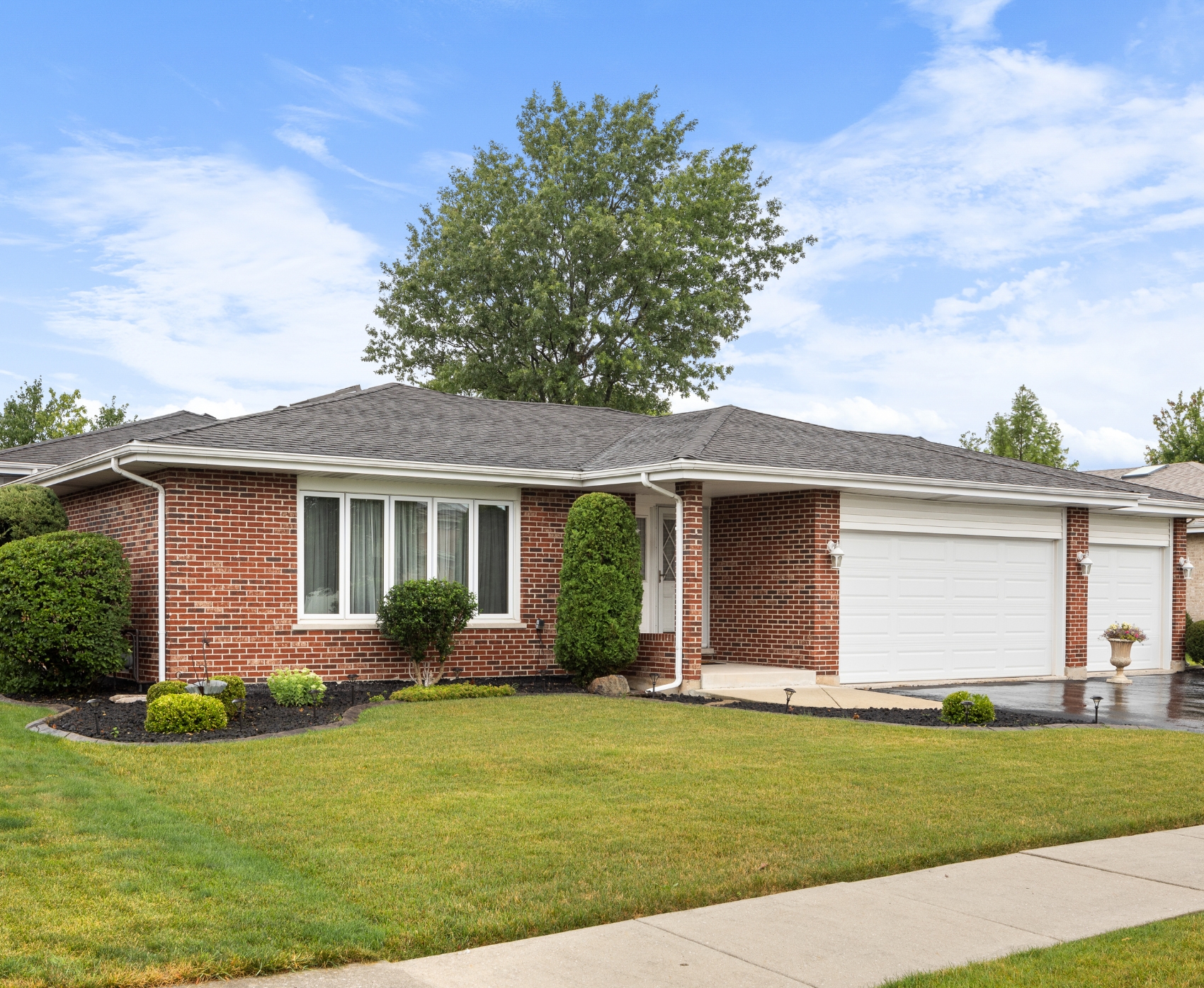 Image of a one level brick house with green lawn