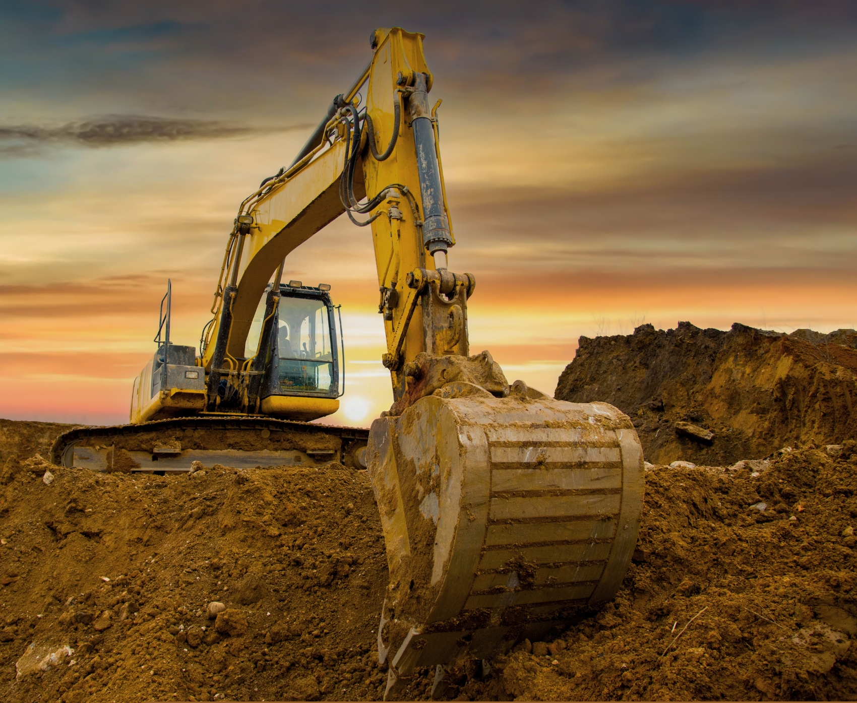 Excavator digging in dirt pile