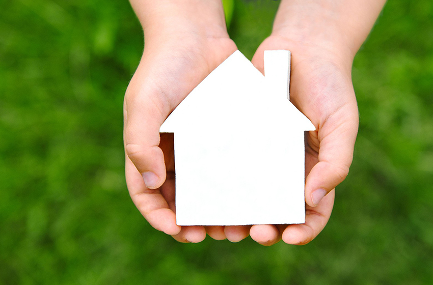Hands holding a house shaped object