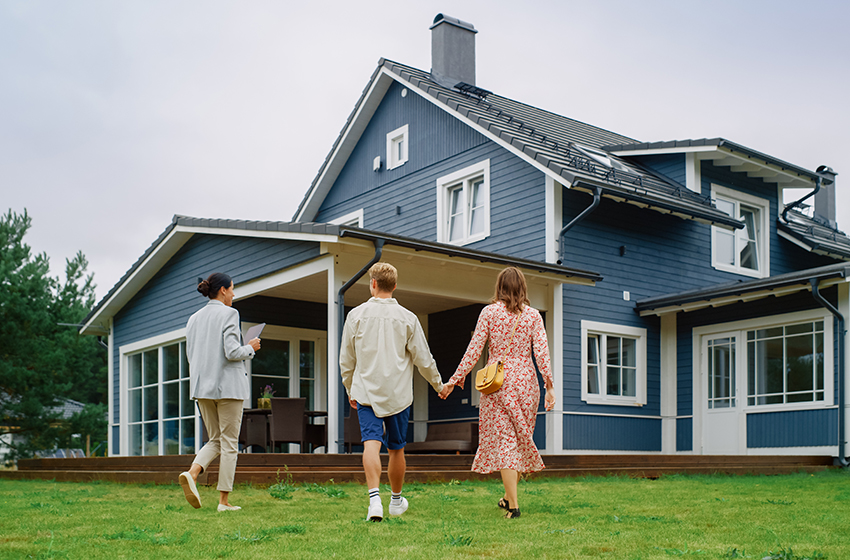Couple walking up to a house with a real estate agent